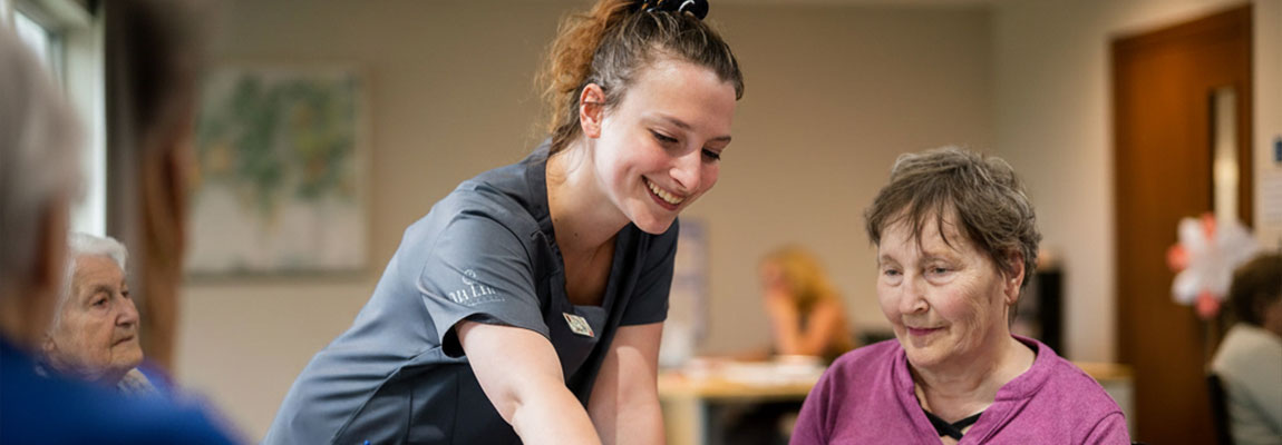 A care team member engaging residents in a daily program.